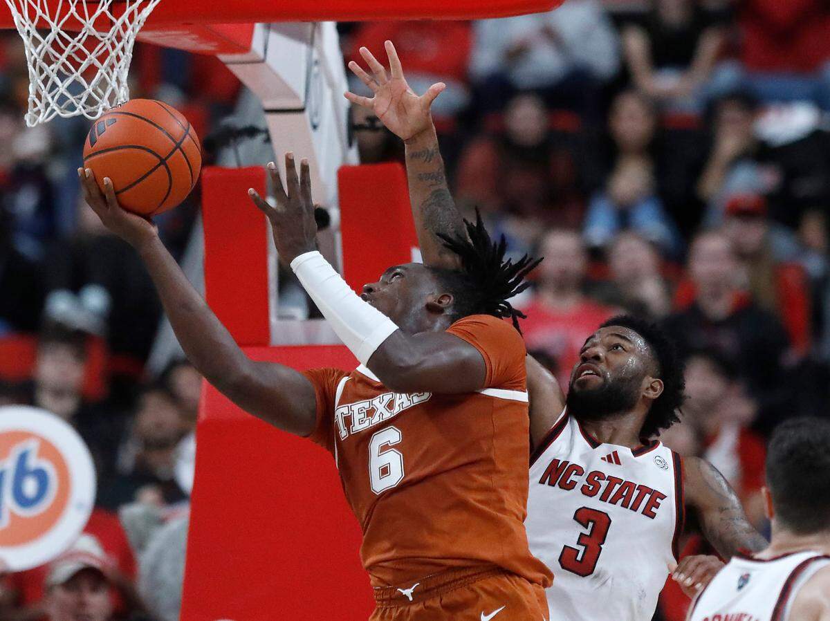Texas’ Arthur Kaluma drives to the basket around N.C. State’s Dontrez Styles during the second half of the Wolfpack’s 63-59 loss on Wednesday, Dec. 4, 2024, at Lenovo Center in Raleigh, N.C.