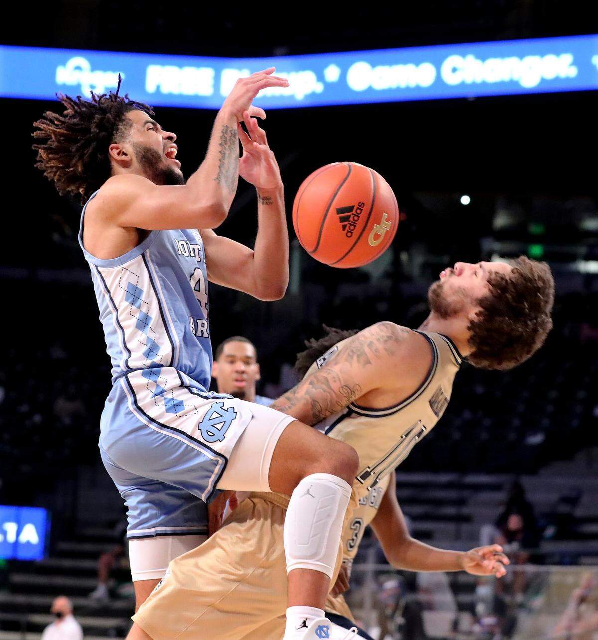 Georgia Tech guard Jose Alvarado draws an offensive foul from North Carolina guard RJ Davis during an NCAA college basketball game Wednesday, Dec. 30, 2020, in Atlanta.