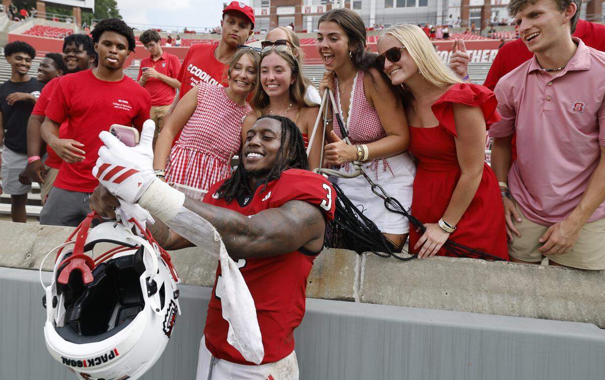 N.C. State running back Hollywood Smothers (3) takes a selfie with fans after N.C. State’s 35-31 victory over Virginia at Carter-Finley Stadium in Raleigh, N.C., Sat. Sept. 6, 2025.
