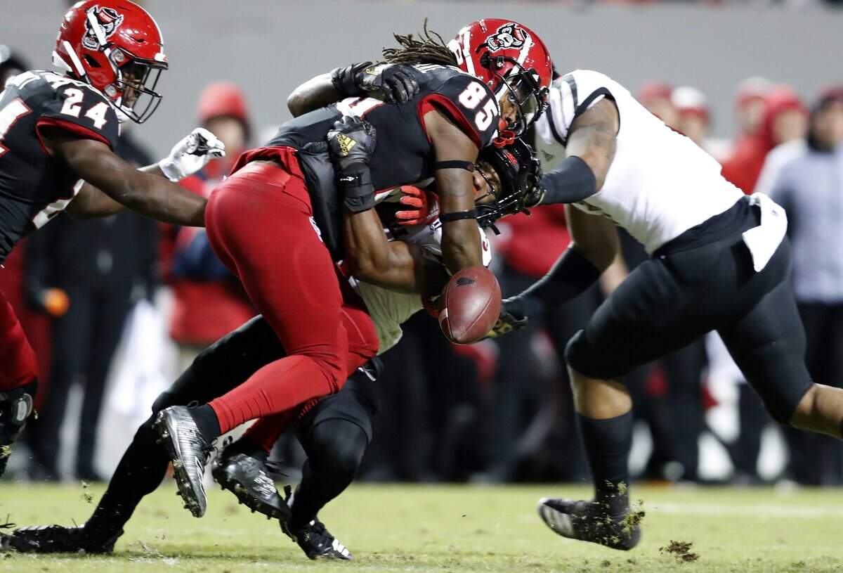 N.C. State wide receiver Keyon Lesane (85) fumbles the ball while being hit by Louisville defensive back Russ Yeast (3) during the second half of Louisville’s 34-20 victory over N.C. State at Carter-Finley Stadium in Raleigh, N.C., Saturday, November 16, 2019.