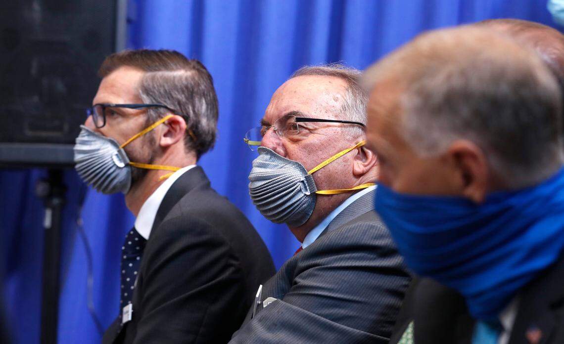 Martin Meeson, CEO Fujifilm Diosynth Biotechnologies, left, and Stanley Erck, CEO of Novavax, center, listen as President Donald Trump participates in a briefing before taking a tour of the Bioprocess Innovation Center at Fujifilm Diosynth Biotechnologies in Morrisville, N.C., Monday, July 27, 2020.