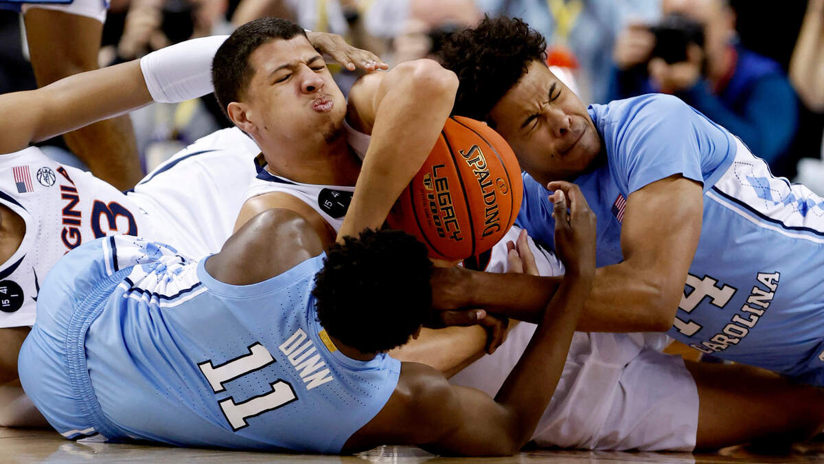 North Carolina’s D’Marco Dunn (11) and Puff Johnson (14) fight for the loose ball with Virginia’s Kadin Shedrick (21) during the first half of UNC’s game against Virginia in the quarterfinals of the ACC Men’s Basketball Tournament in Greensboro, N.C., Thursday, March 9, 2023.