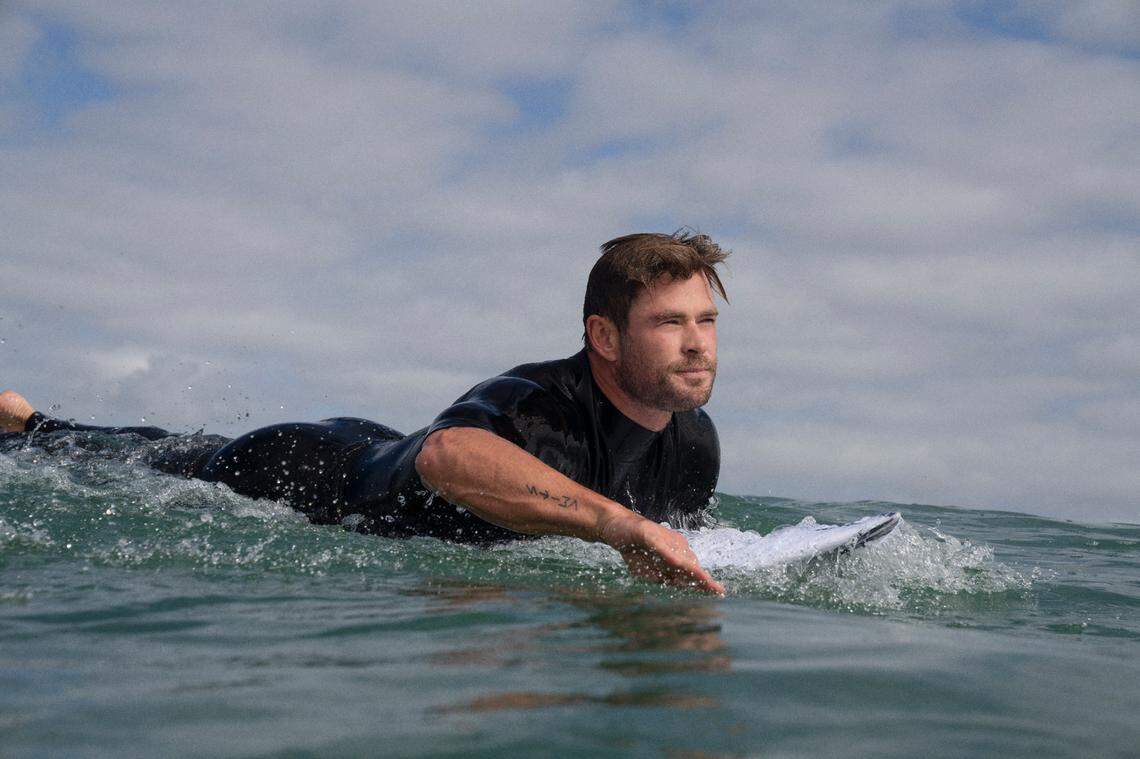 Chris Hemsworth paddling out to surf for the National Geographic SharkFest special “Shark Beach with Chris Hemsworth.”