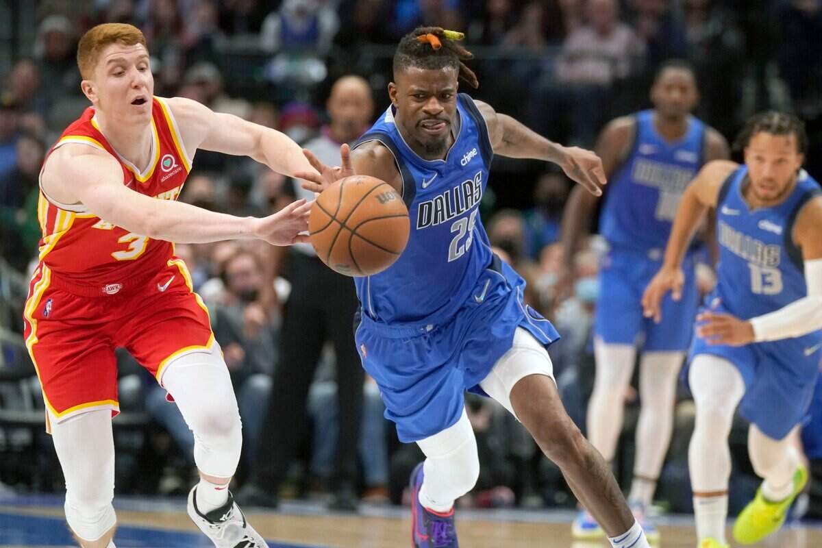 Dallas Mavericks forward Reggie Bullock (25) steals the ball from Atlanta Hawks guard Kevin Huerter (3) during the second half of an NBA basketball game in Dallas, Sunday, Feb. 6, 2022. The Mavericks won 103-94. (AP Photo/LM Otero)