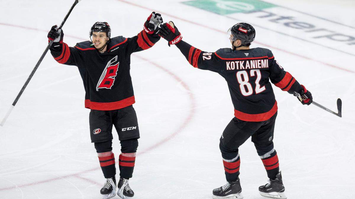 Carolina Hurricanes center Logan Stankoven (22) celebrates with Jesperi Kotkaniemi (82) after a goal by left wing Taylor Hall in the second period against the New Jersey Devils during Game 5 of their Stanely Cup series on Tuesday, April 29, 2025 at Lenovo Center in Raleigh, N.C.
