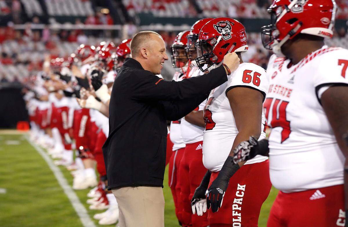 N.C. State coach Dave Doeren talks with guard Joshua Fedd-Jackson (66) during warmups before the Wolfpack’s game against Texas A&M in the Gator Bowl at TIAA Bank Field in Jacksonville, Fla., Monday, Dec. 31, 2018.