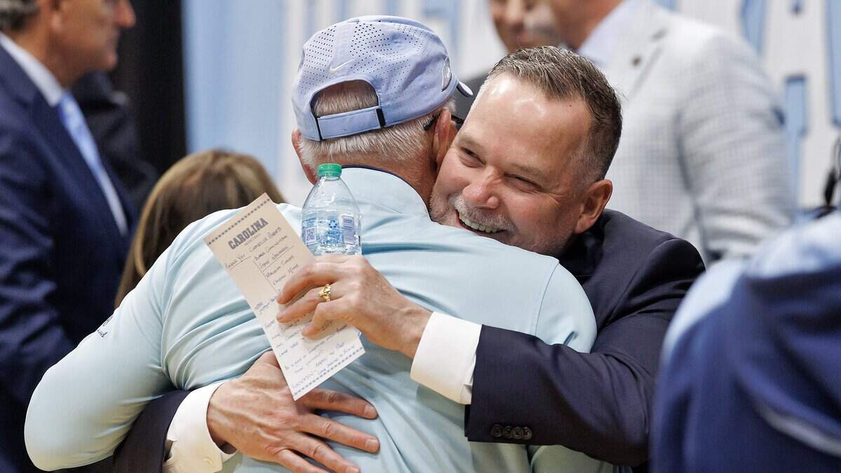 New North Carolina men’s basketball head coach Michael Malone receives a hug following an introductory press conference at the Smith Center on Tuesday, April 7, 2026, in Chapel Hill, N.C.