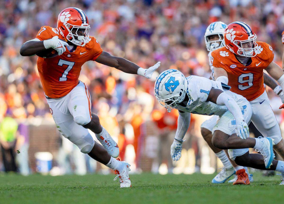 Clemson’s Phil Mafah (7) looks for running room against North Carolina’s Antavious Lane (1) in the second quarter on Saturday, November 18, 2023 at Memorial Stadium in Clemson, S.C.