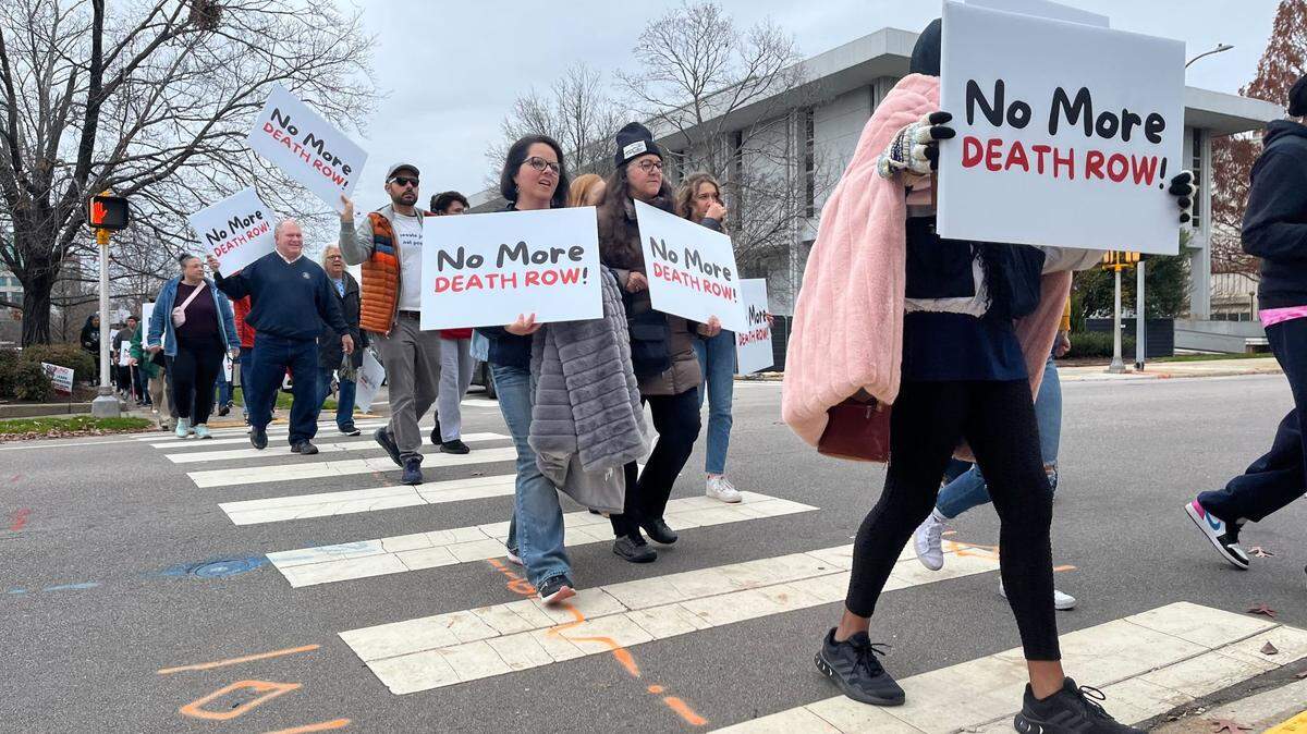 People march down Jones Street, across from the North Carolina Executive Mansion in downtown Raleigh, on Saturday, Dec. 10, in protest of the death penalty in the state.