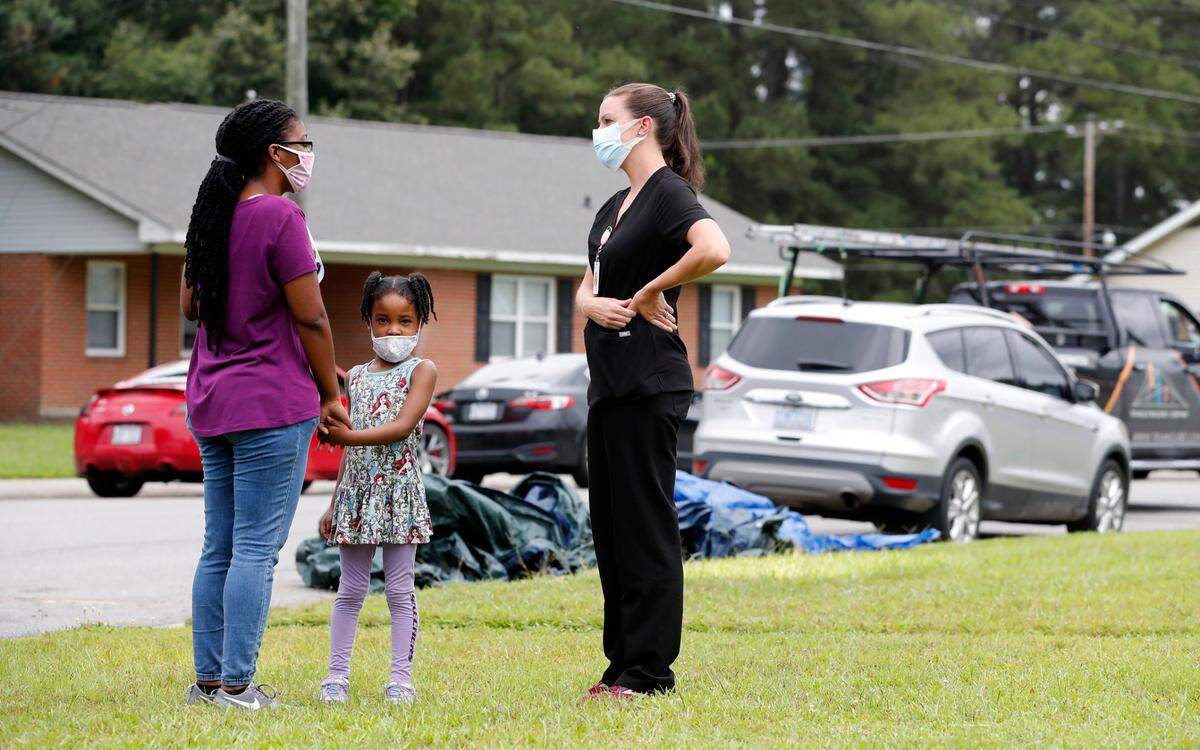 Erin Smith, family nurse practitioner with the Johnston County Public Health Department, talks with Briona Davis after she received a COVID-19 vaccine shot during a pop up vaccine clinic in the Smithfield Housing Authority’s subdivision of Woodall Heights in Smithfield, N.C. Tuesday, June 8, 2021. With Davis is her daughter, Rayona Jones.