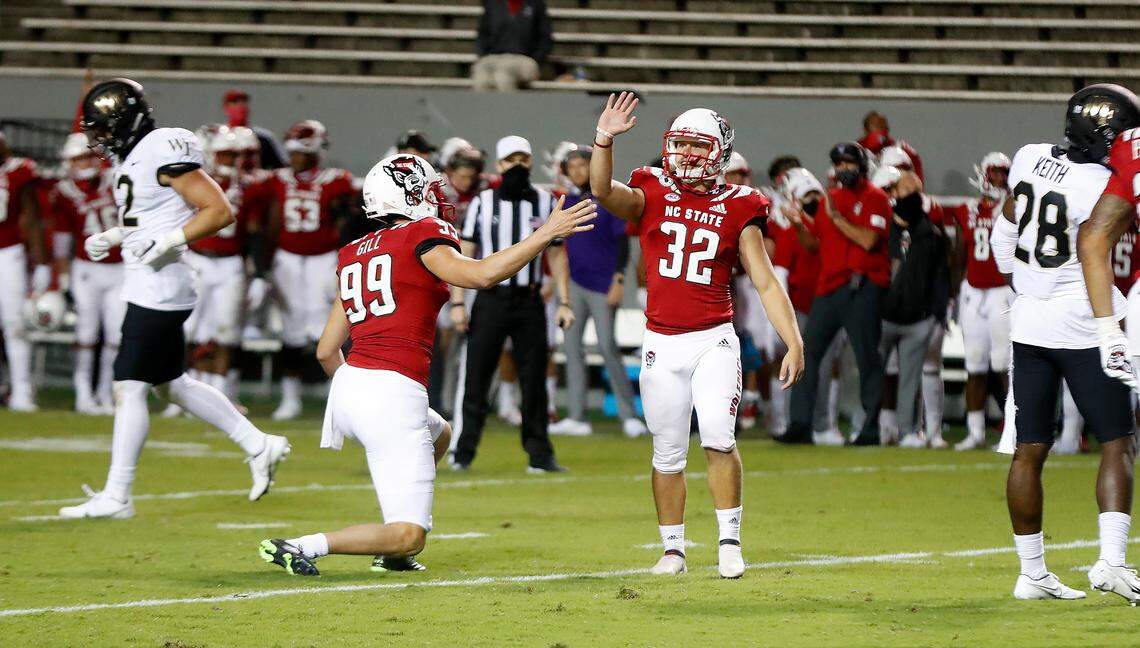 N.C. State place kicker Christopher Dunn (32) waves at the Wake Forest bench after kicking a 30-yard field goal during the second half of N.C. State’s 45-42 victory over Wake Forest at Carter-Finley Stadium in Raleigh, N.C, Saturday, Sept. 19, 2020. N.C. State’d Trenton Gill (99) is to the left.
