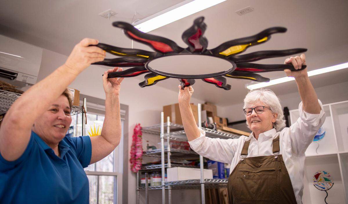Jody Eimers, right, helps her wife Joni White, left, plan a glass art piece in her workshop at their home in Hillsborough, N.C. on Feb. 14, 2022.