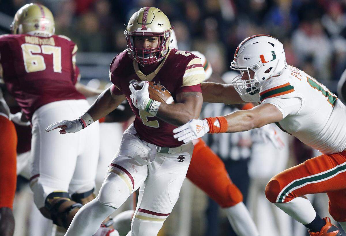 Boston College running back AJ Dillon (2) carries the ball past Miami defensive lineman Scott Patchan (19) during the second half of an NCAA college football game in Boston, Friday, Oct. 26, 2018.