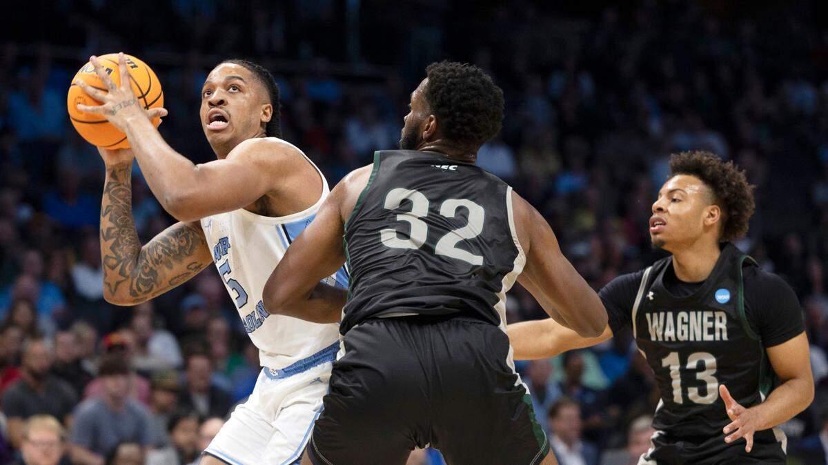 North Carolina’s Armando Bacot (5) works his way to the basket against Wagner’s Keyontae Lewis (32) and Julian Brown (13) in the first half on Thursday, March 21, 2024 during the NCAA Tournament at Spectrum Center in Charlotte, N.C.