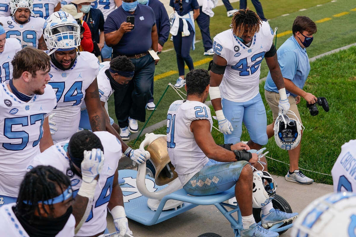 North Carolina Tar Heels players celebrate keeping the victory bell after the win over the Duke Blue Devils at Wallace Wade Stadium. 