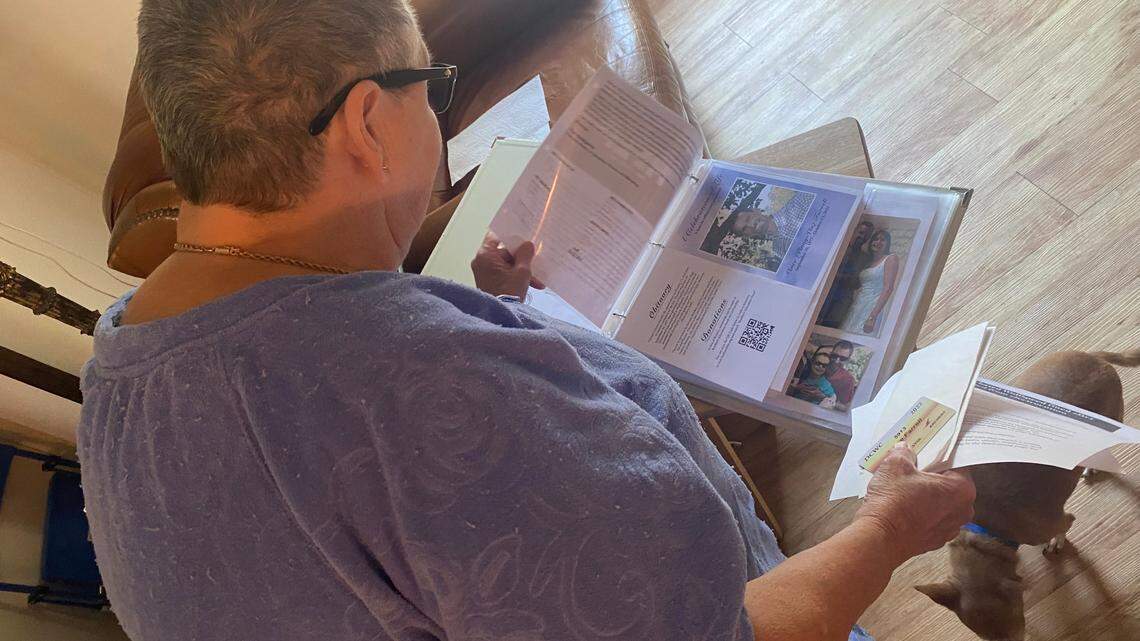 Pat Bryant flips through a binder memorializing her son Vincent who was killed during a workplace accident at Wolfspeed on Oct. 13, 2022. 
