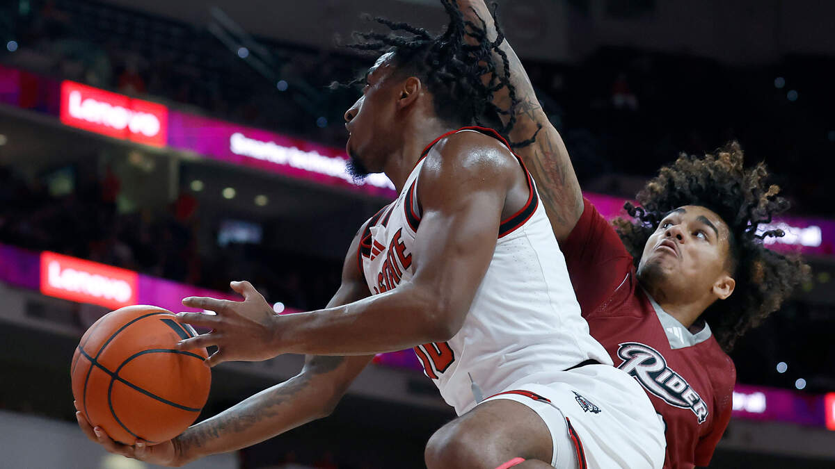 N.C. State’s Marcus Hill drives to the basket around Rider’s Ruben Rodriguez during the first half of the Wolfpack’s game on Sunday, Dec. 22, 2024, at Lenovo Center in Raleigh, N.C.