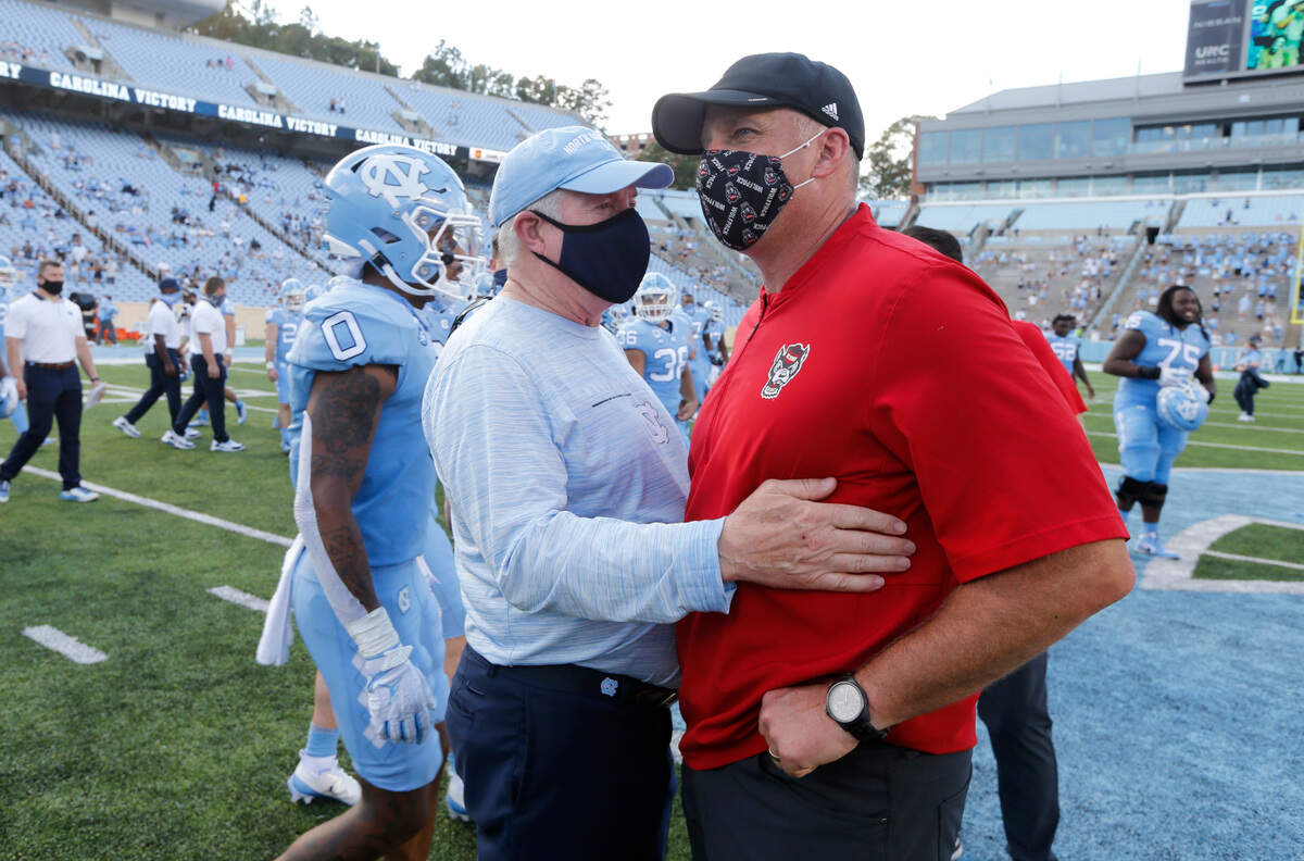 North Carolina head coach Mack Brown talks with N.C. State head coach Dave Doeren after UNC’s 48-21 victory over N.C. State at Kenan Stadium in Chapel Hill, N.C., Saturday, Oct. 24, 2020.
