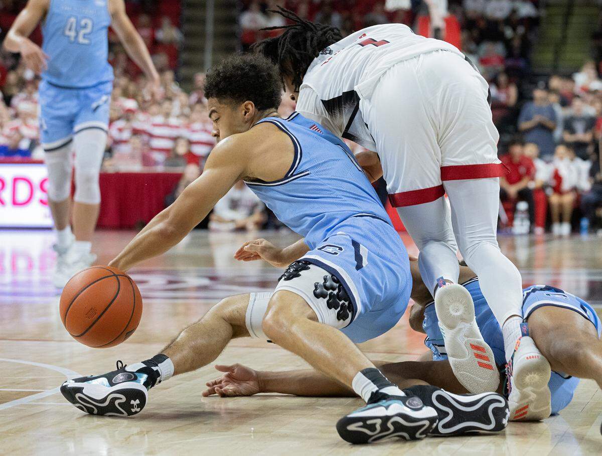 The Citadel’s AJ Smith and N.C. State’s Jayden Taylor dive on the floor for a loose ball during the second half of the Wolfpack’s 72-59 win on Monday, Nov. 6, 2023, at PNC Arena in Raleigh, N.C.