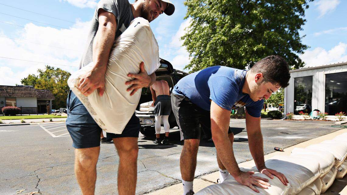 David Hewitt, left, and Ed Piewonsky, right, members at 12th State Crossfit in Raleigh, help sandbag the building in preparation for Hurricane Florence on Wednesday, Sept. 12, 2018. The gym, which was hit hard by flooding caused by Hurricane Matthew, asked members to help them move gym equipment and prepare for the storm.