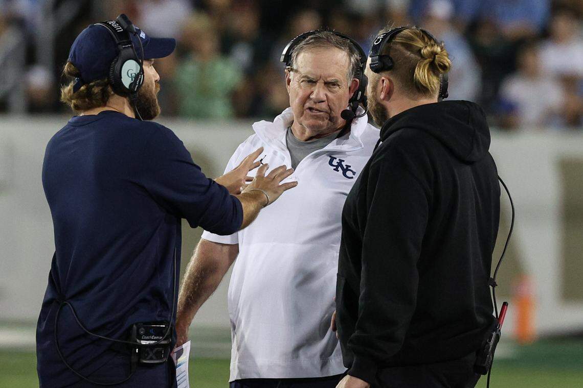 Chapel Hill Head Coach Bill Belichick, center, talks to defensive coordinator and son, Steve Belichick, right, during a timeout at the game against UNC-Charlotte at Jerry Richardson Stadium in Charlotte on Saturday, September 6, 2025.