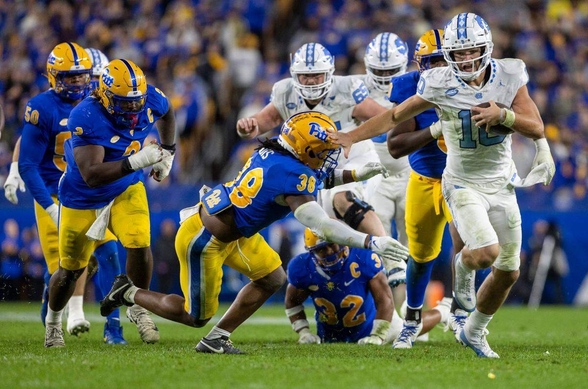 North Carolina quarterback Drake Maye (10) stiff arms Pitt’s Kyle Lewis (38) as he picks up 15-yards in the second quarter on Saturday, September 23, 2023 at Acrisure Stadium in Pittsburgh, Pa.