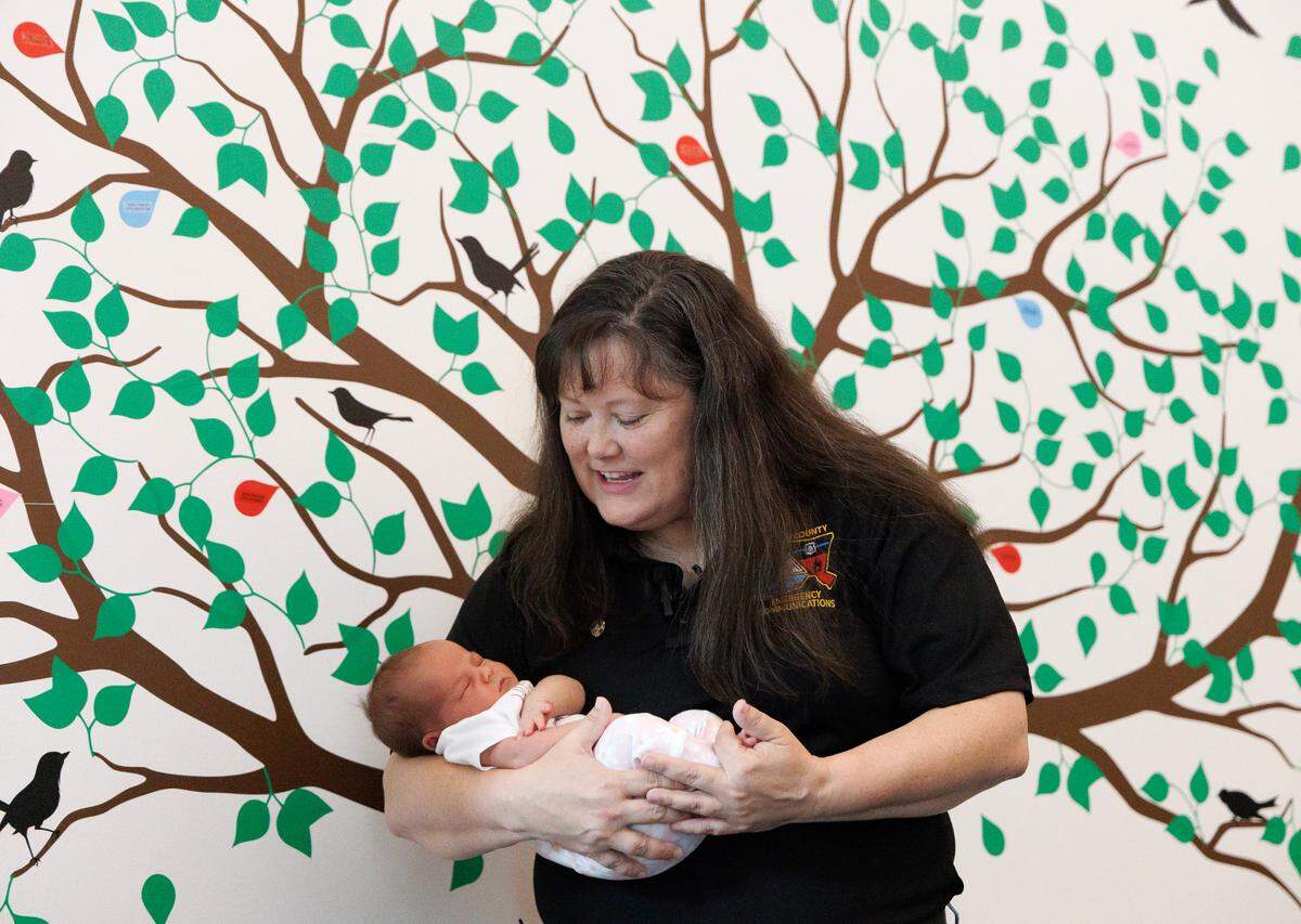 Chatham County 911 operator Lorie Teague meets two-week-old Daisy, who she helped deliver over the phone.