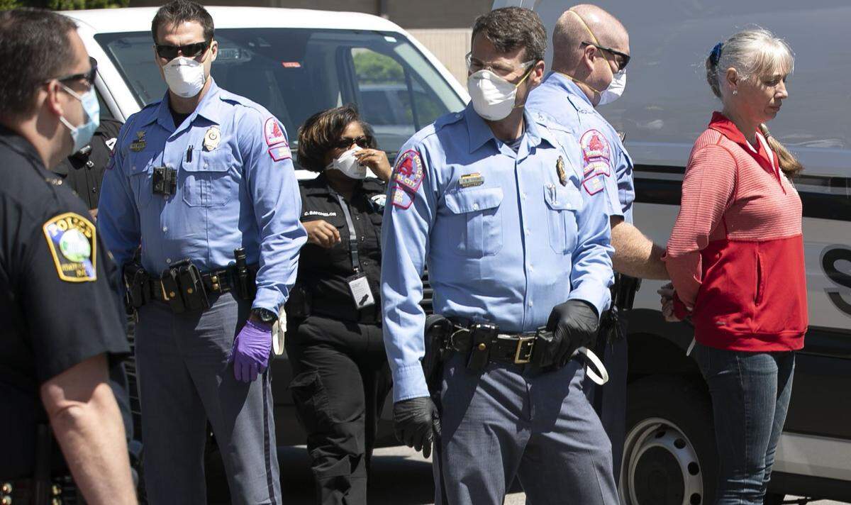 Police arrest a woman after she was told several times to disperse from a gathering of protestors calling on Governor Roy Cooper to re-open North Carolina, amid concerns of the economic fallout from his stay at home order due to the COVID-19 virus. Protestor gathered at the corner of N. Wilmington and Jones Street for nearly two hours before being ordered to disperse on Tuesday, April 14, 2020 in Raleigh, N.C.