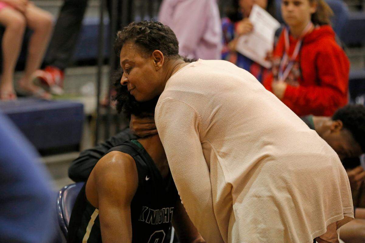Greenfield’s Coby White’s mother embraces her son after a hard fought loss to Trinity Christian School. The Neuse Christian Academy Lions and Northwood Temple Academy Eagles girls and Greenfield Knights and Trinity Christian School Crusaders boys played at Forsyth Country Day School in the NCISAA Class 1A Final basketball tournament championships on Feb. 24, 2018.