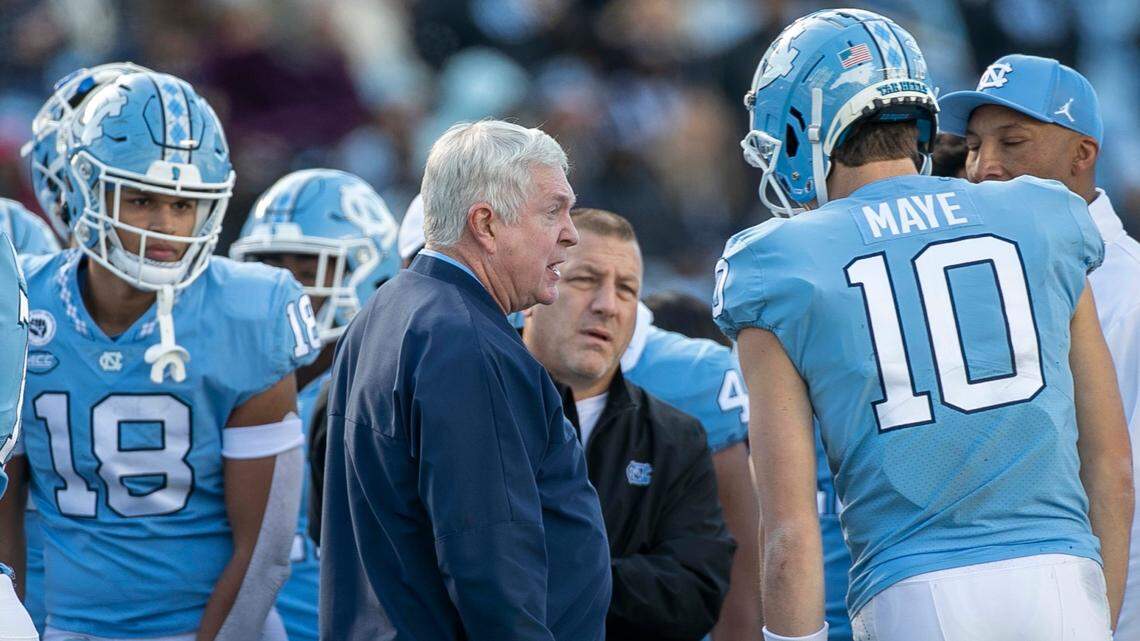 North Carolina coach Mack Brown and offensive coordinator Phil Longo confer with quarterback Drake Maye (10) in the fourth quarter against Wofford on Saturday, November 20, 2021 at Kenan Stadium in Chapel Hill, N.C.