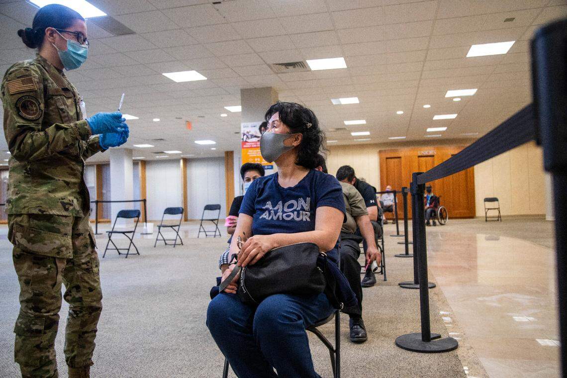 Kimberly Newman, a U.S. Air Force medic, prepares to administer a vaccination to Jeong Hwa Song during a mass vaccination clinic Wednesday, March 10, 2021 at Four Season Town Center in Greensboro. The clinic expects to vaccinate 3000 people per day over eight weeks.