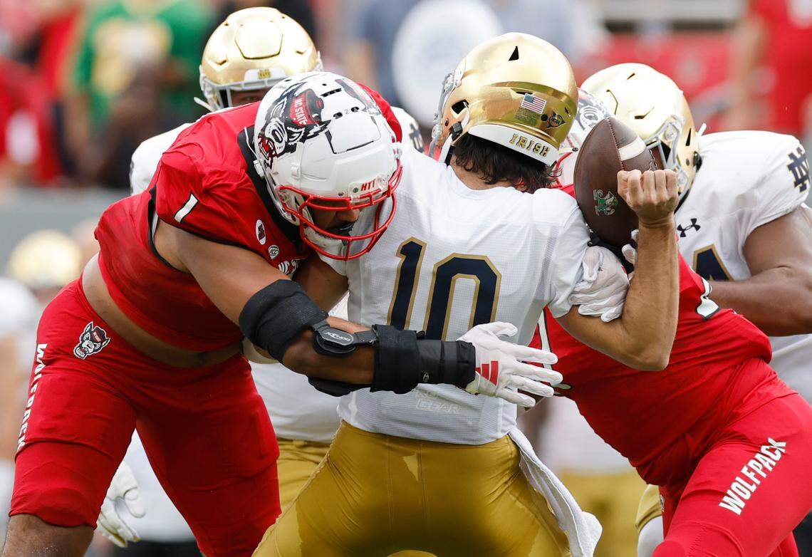 N.C. State defensive tackle Davin Vann (1) sacks Notre Dame quarterback Sam Hartman (10) causing him to fumble during the first half of N.C. State’s game against Notre Dame at Carter-Finley Stadium in Raleigh, N.C., Saturday, Sept. 9, 2023. Notre Dame recovered the fumble.