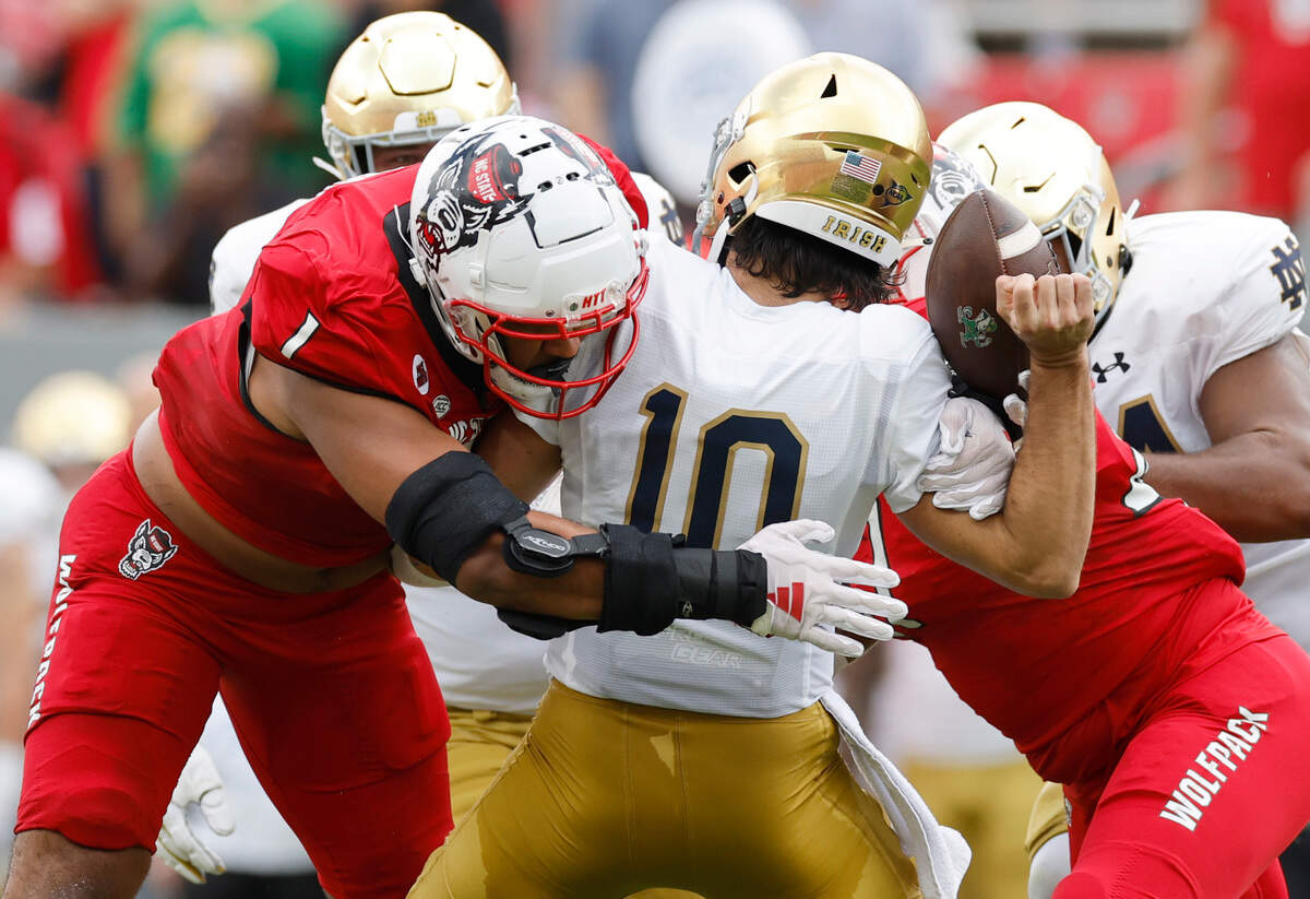 N.C. State defensive tackle Davin Vann (1) sacks Notre Dame quarterback Sam Hartman (10) causing him to fumble during the first half of N.C. State’s game against Notre Dame at Carter-Finley Stadium in Raleigh, N.C., Saturday, Sept. 9, 2023. Notre Dame recovered the fumble.