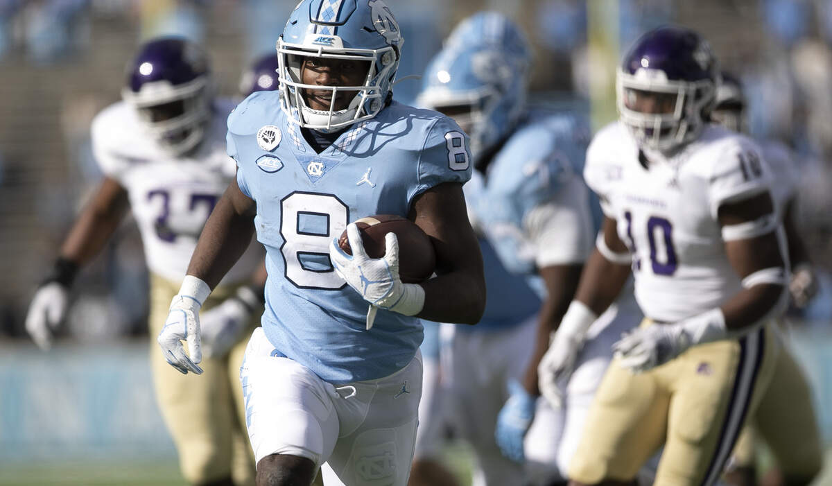 North Carolina’s Michael Carter (8) scores on a 17-yard carry to give the Tar Heels’ a 7-0 lead over Western Carolina in the first quarter on Saturday, December 5, 2020 at Kenan Stadium in Chapel Hill, N.C.