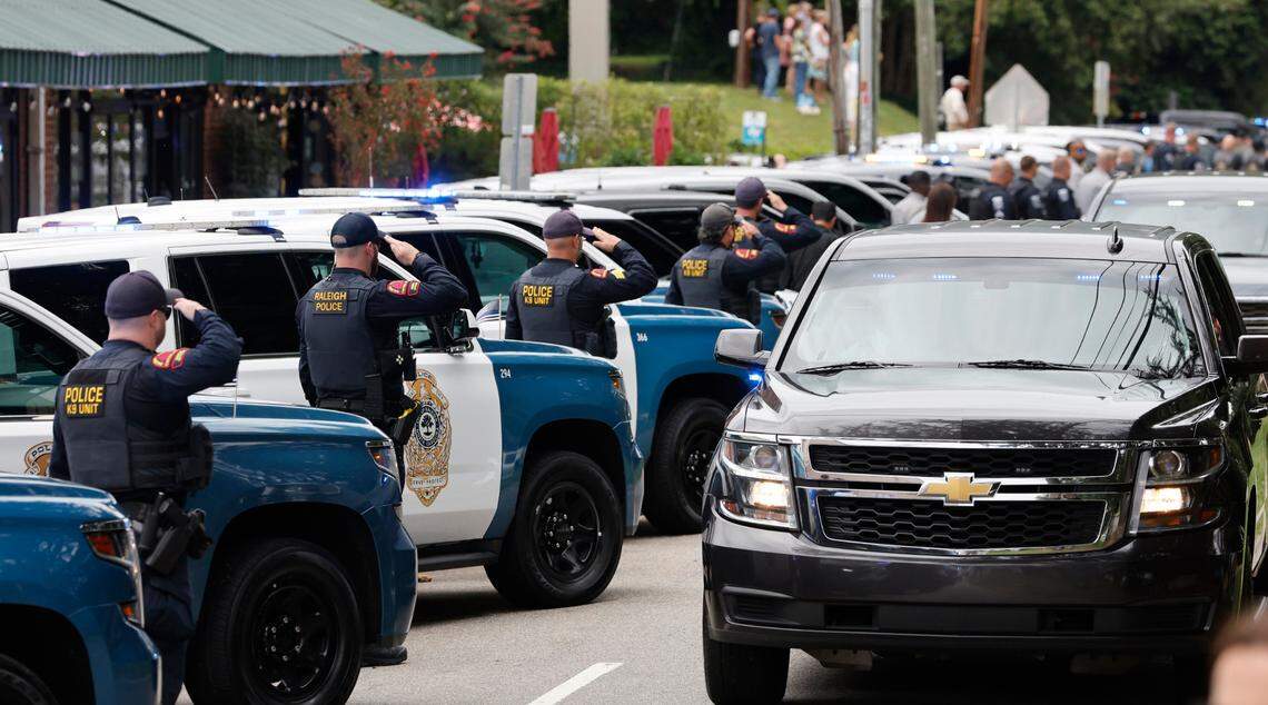 K9 officers salute as a procession for slain Wake County Sheriffís Deputy Ned Byrd comes down Glenwood Avenue past the Five Points neighborhood in Raleigh, N.C., Friday, August 19, 2022.