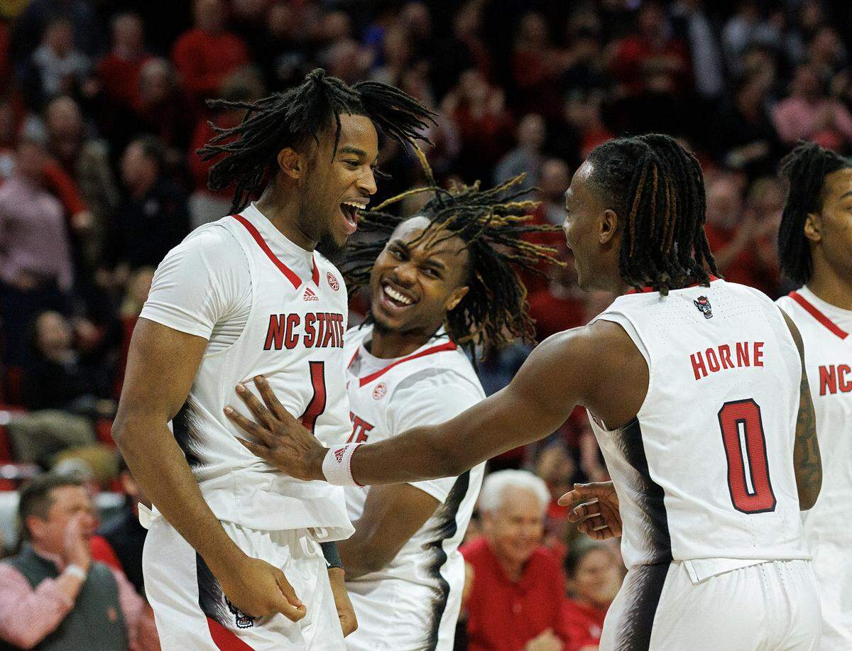 N.C. State’s Jayden Taylor celebrates with teammates Kam Woods and DJ Horne late in the second half of the Wolfpack’s 83-76 win over Wake Forest at PNC Arena on Tuesday, Jan. 16, 2024, in Raleigh, N.C.