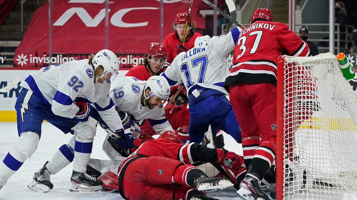 Tampa Bay Lightning left wing Alex Killorn (17), right wing Alexander Volkov (92) and right wing Barclay Goodrow (19) pile in on Carolina Hurricanes goaltender James Reimer as Carolina Hurricanes right wing Andrei Svechnikov (37) defends during the first period of an NHL hockey game in Raleigh, N.C., Monday, Feb. 22, 2021. (AP Photo/Gerry Broome)