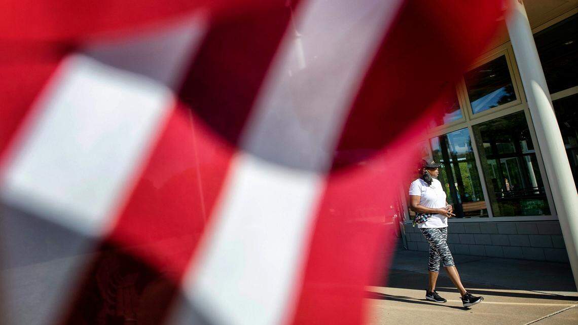 Kim Best walks by an American flag outside of the John Chavis Memorial Park Community Center polling site on Tuesday, May 17, 2022, in Raleigh, N.C.