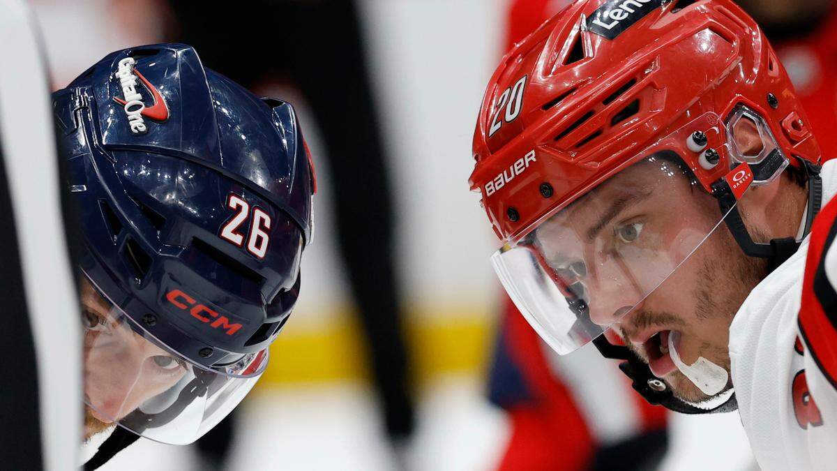 Washington Capitals center Nic Dowd (26) and Carolina Hurricanes center Sebastian Aho (20) prepare to take a face-off in the second period in game one of the second round of the 2025 Stanley Cup Playoffs at Capital One Arena. 