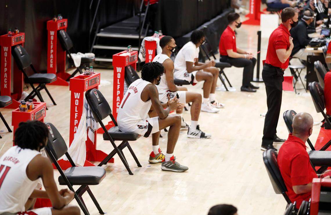 N.C. State players, including Dereon Seabron (1) watch from the bench area during the second half of N.C. State’s 95-61 victory over Charleston Southern in the Wolfpack Invitational at Reynolds Coliseum in Raleigh, N.C., Wednesday, Nov. 25, 2020.