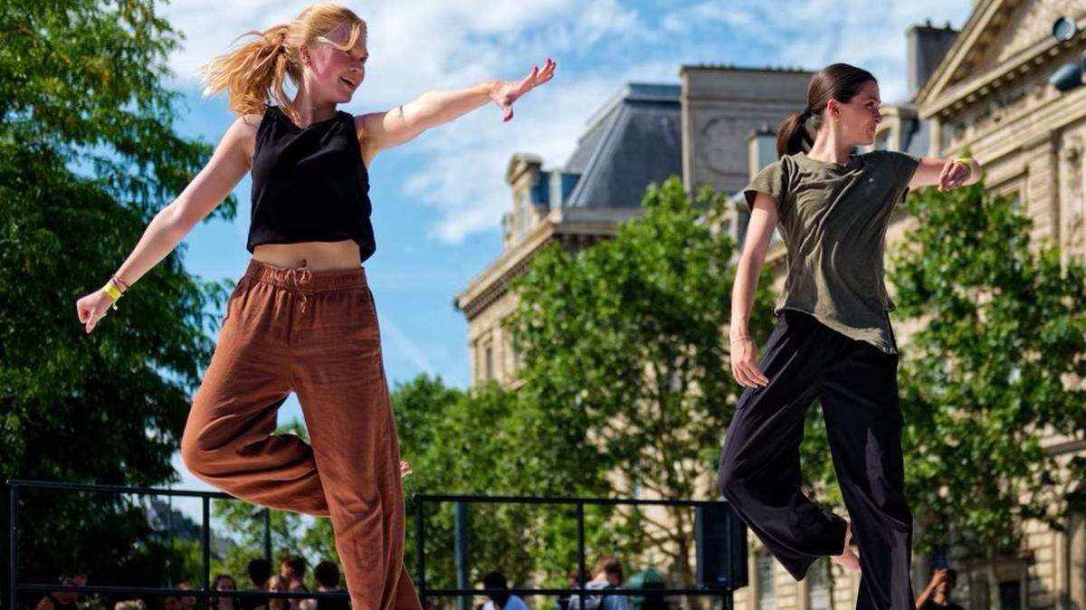 Ava Cutlip (left) and Emma Pinnix of Boone, NC, dance during a July showcase event in Paris in advance of the 2024 Olympic Games.