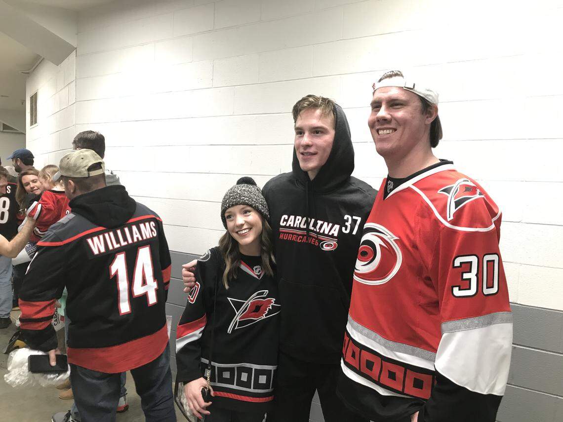 Carolina Hurricanes forward Andrei Svechnikov, middle in No. 37, poses for a photo during a meet and greet with Canes fans after a game at PNC Arena.