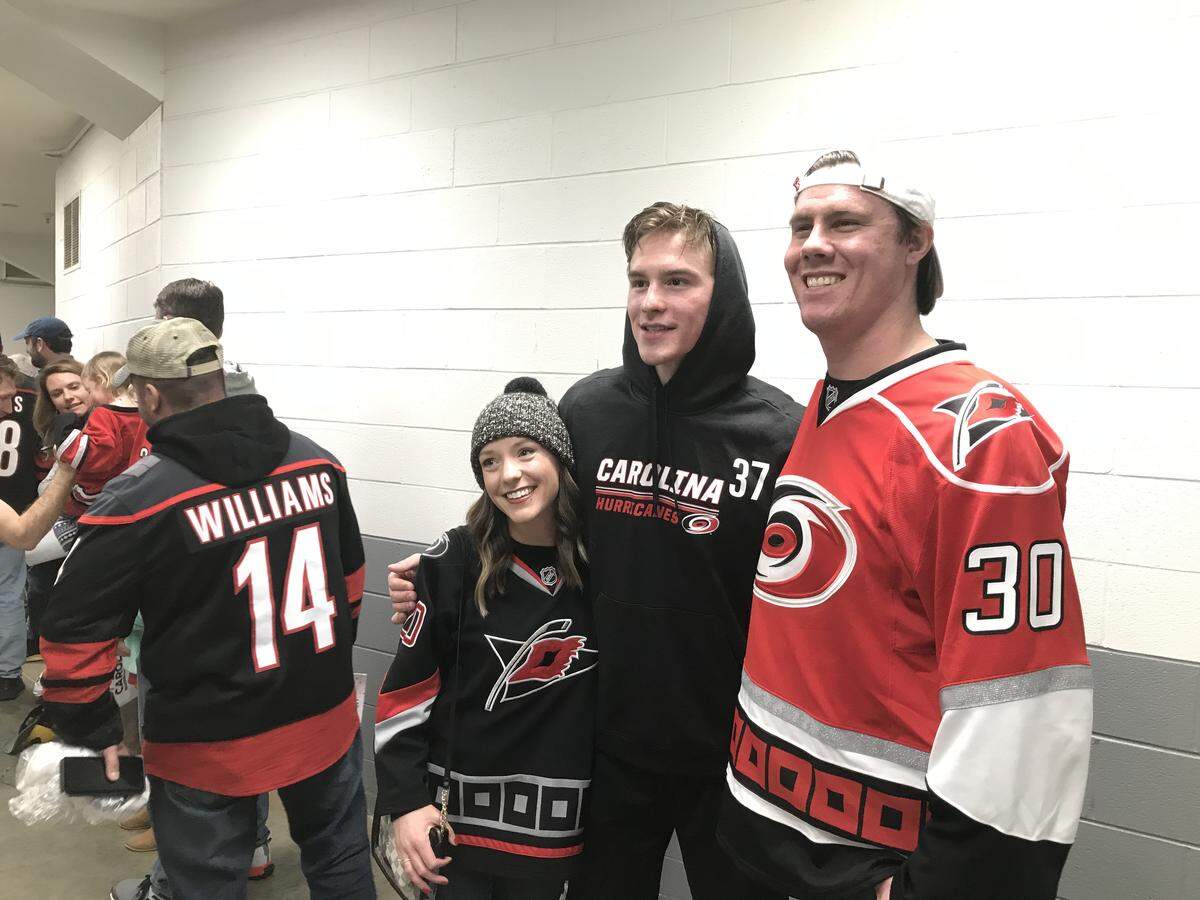 Carolina Hurricanes forward Andrei Svechnikov, middle in No. 37, poses for a photo during a meet and greet with Canes fans after a game at PNC Arena.