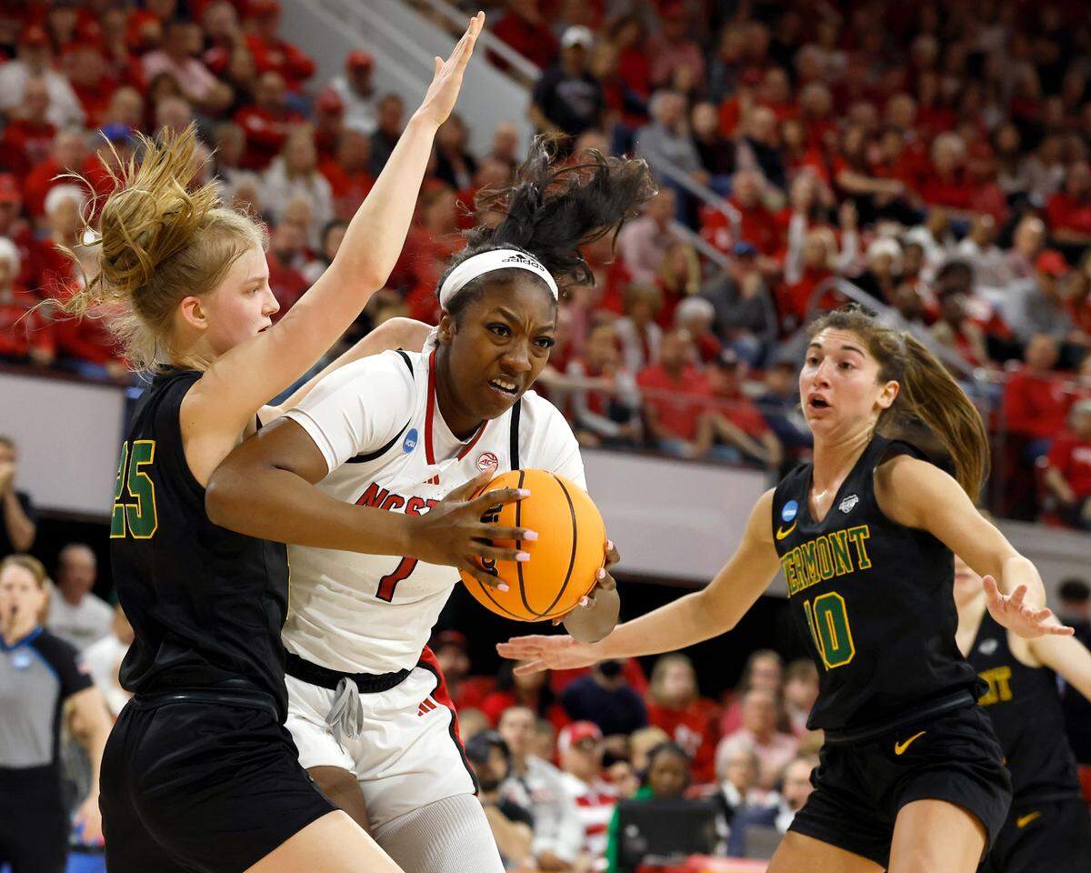 N.C. State’s Lorena Awou powers to the basket past Vermont’s Nikola Priede and Bella Vito during the first half of the Wolfpack’s first round NCAA Tournament game on Saturday, March 22, 2025, at Reynolds Coliseum in Raleigh, N.C.