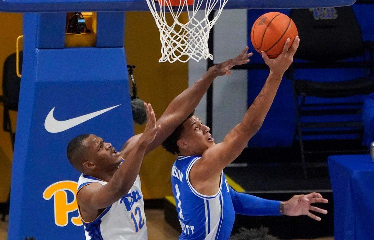 Pittsburgh’s Abdoul Karim Coulibaly (12) defends as Duke’s Jalen Johnson shoots during the second half of an NCAA college basketball game Tuesday, Jan. 19, 2021, in Pittsburgh. Pittsburgh won 79-73.