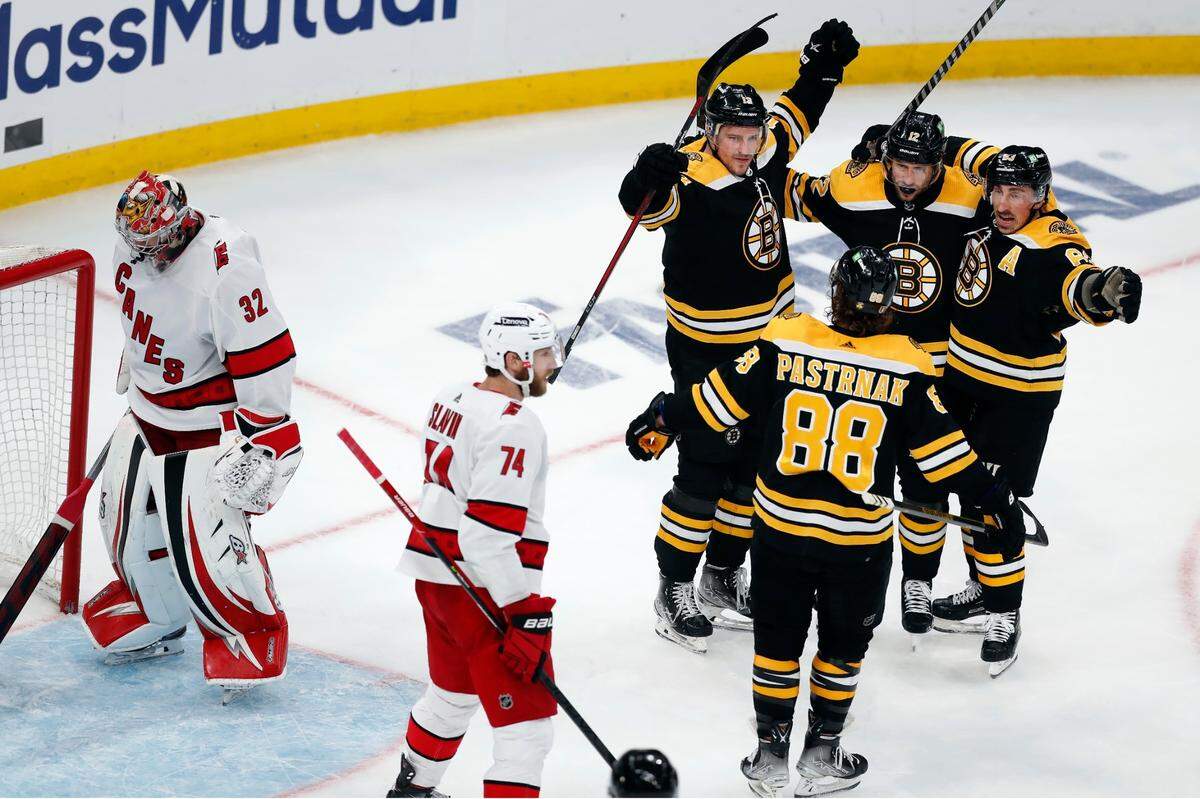 Boston Bruins’ Charlie Coyle (13) celebrates with teammates after scoring on Carolina Hurricanes goalie Antti Raanta (32) during the second period in Game 6 of an NHL hockey Stanley Cup first-round playoff series Thursday, May 12, 2022, in Boston.