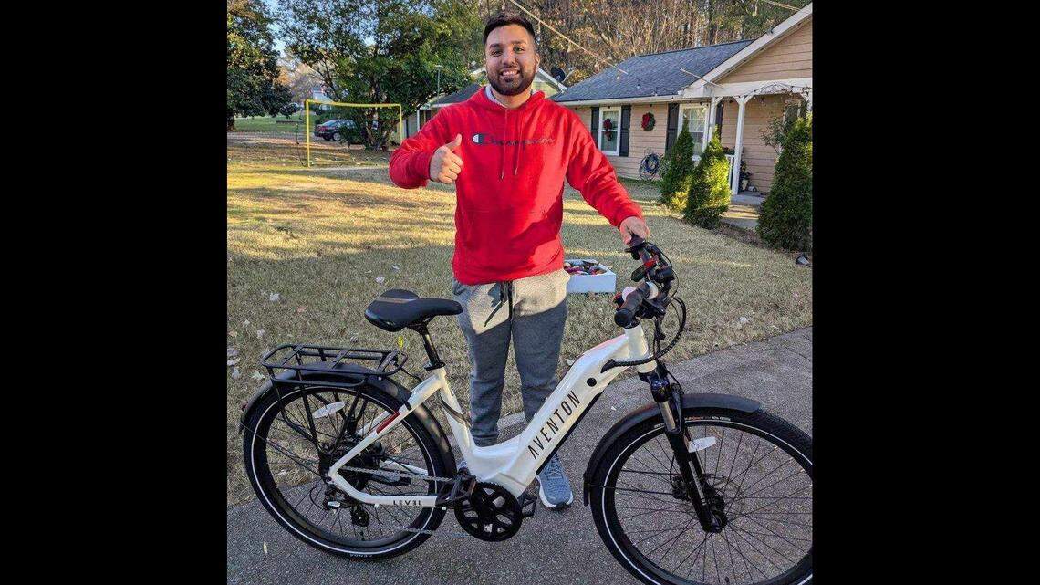 Raleigh resident Jason Peña-Hernandez poses with his new e-bike purchased with a voucher he received from the city through their E-Bike Rebate Program this fall.