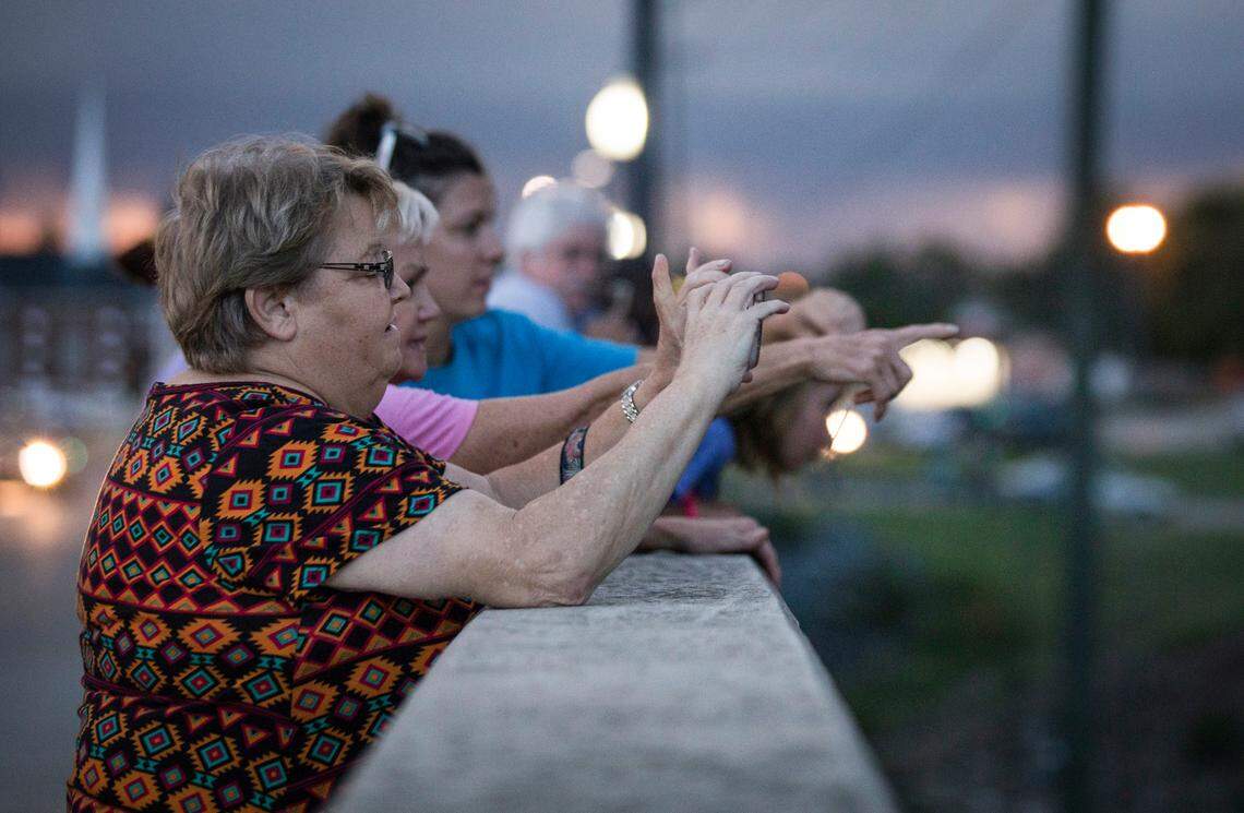 Jane Horne of Stedman, N.C. takes a picture of the sunset over the rising Cape Fear River from the bridge on Person St. in Fayetteville, N.C. on Monday, September 17, 2018.