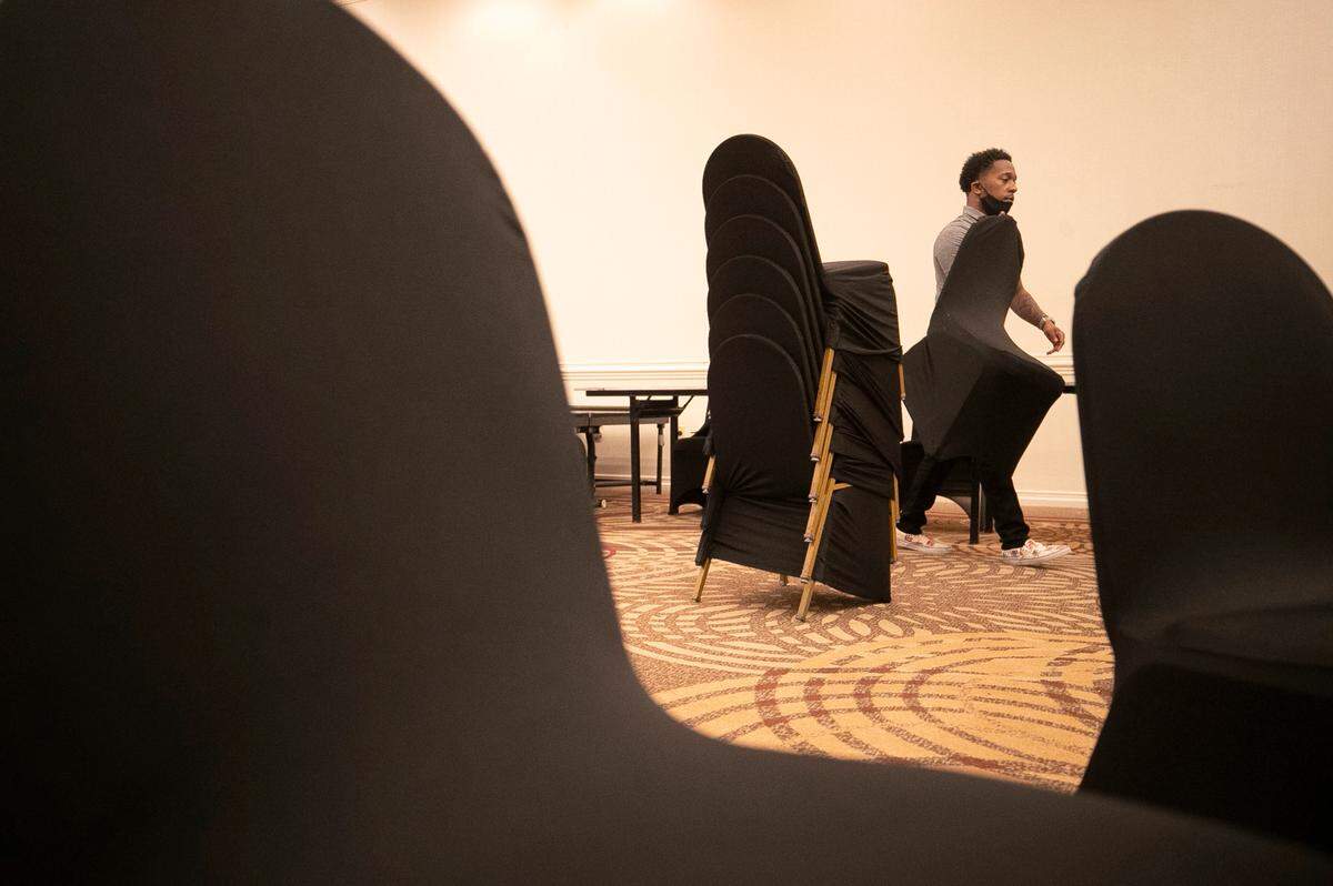 Kobe Morgan sets up a banquet room at the Sheraton Hotel on Fayetteville Street on Tuesday, October 26, 2021 in Raleigh, N.C. Morgan, a St. Augustine’s University student has been working at the Sheraton for the past seven months.