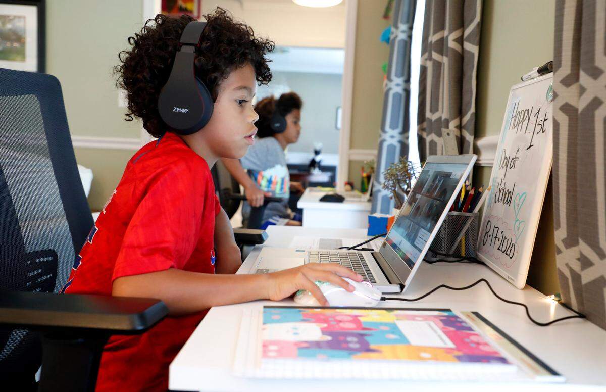 Sky Grimmett, foreground, and his brother, Harper, attend online classes at their home in Raleigh on the first day of school Monday, August 17, 2020. Sky is a third grader at Hunter Elementary School and Harper is a sixth grader at Ligon Middle School.